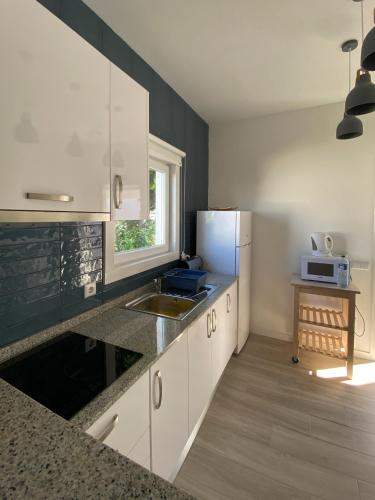 a kitchen with white cabinets and a sink at Perto do Mar, Alojamento Local in Gafanha da Boa Hora