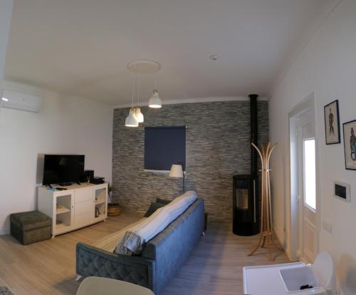 a living room with a couch and a brick wall at Perto do Mar, Alojamento Local in Gafanha da Boa Hora