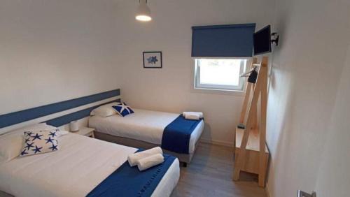 mały pokój z 2 łóżkami i telewizorem w obiekcie Perto do Mar, Alojamento Local w mieście Gafanha da Boa Hora