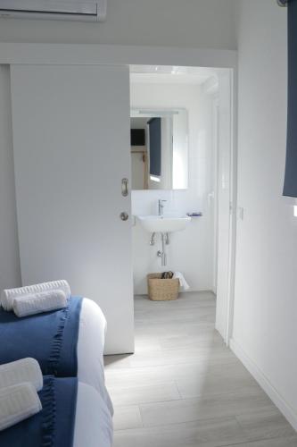 a bathroom with a sink and a bed in a room at Perto do Mar, Alojamento Local in Gafanha da Boa Hora