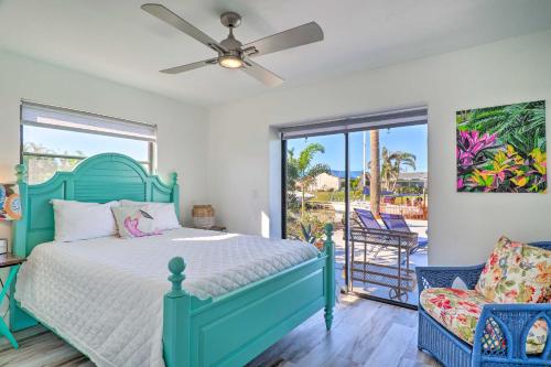 a bedroom with a blue bed and a balcony at Beachy Cape Coral Home - Swim, Fish, Boat! in Cape Coral