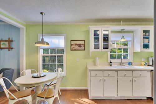 eine Küche mit grünen Wänden, einem Tisch und einem Waschbecken in der Unterkunft Happy Cottage - 504 Sea Breeze Dr in Demere Park