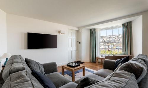 a living room with a couch and a flat screen tv at Coral in Brixham