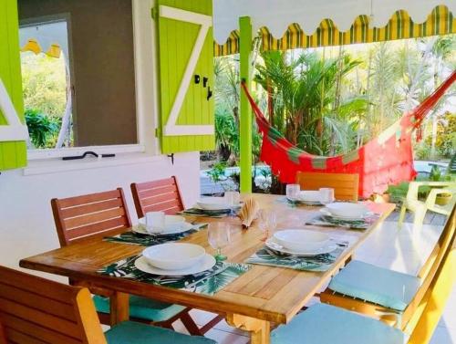 a dining room with a wooden table and chairs at Villa TrÔpik Diamond + Bungalow in Le Diamant
