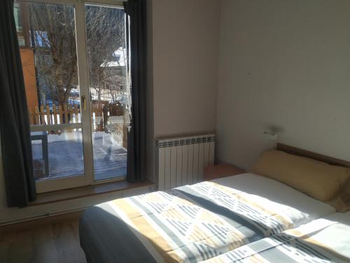 1 dormitorio con cama y ventana grande en Apartamento Arce II en al Valle de Benasque, en Castejón de Sos