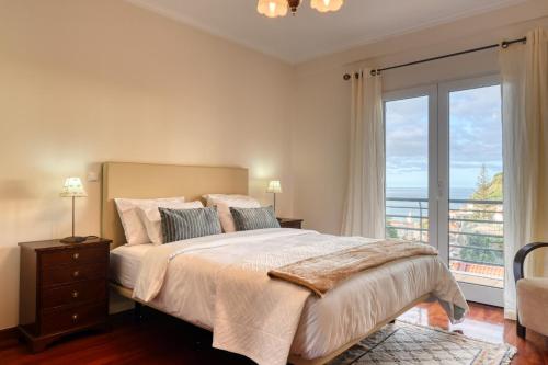 - une chambre avec un grand lit et une grande fenêtre dans l'établissement Lidia's Place, a Home in Madeira, à Ponta do Sol