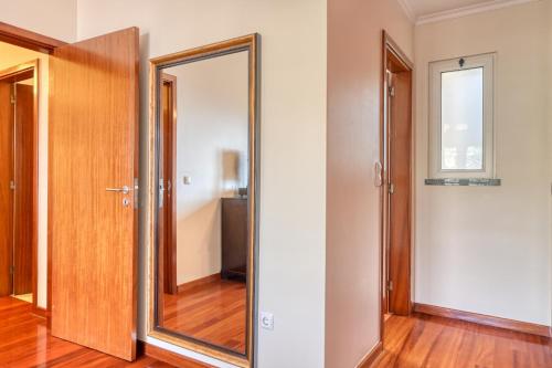 a hallway with a mirror and a door at Lidia's Place, a Home in Madeira in Ponta do Sol