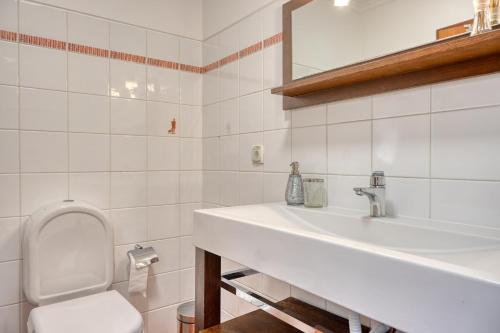 a white bathroom with a sink and a toilet at Lidia's Place, a Home in Madeira in Ponta do Sol