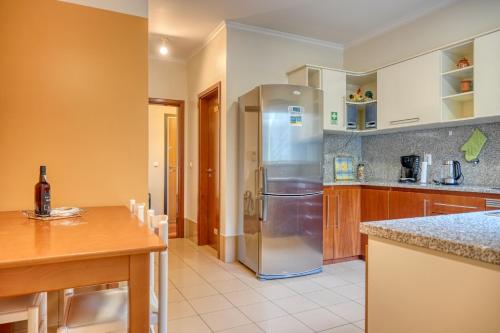 a kitchen with a stainless steel refrigerator and a table at Lidia's Place, a Home in Madeira in Ponta do Sol