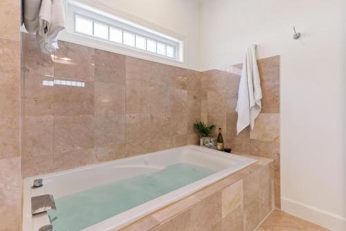 eine Badewanne im Bad mit Fenster in der Unterkunft Beach Chickens - 1019 Mallery Street in Mallory Park