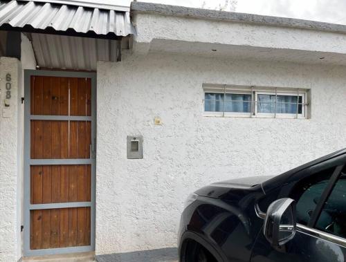 un coche aparcado frente a una casa blanca en Departamento El Portal - San Rafael en San Rafael