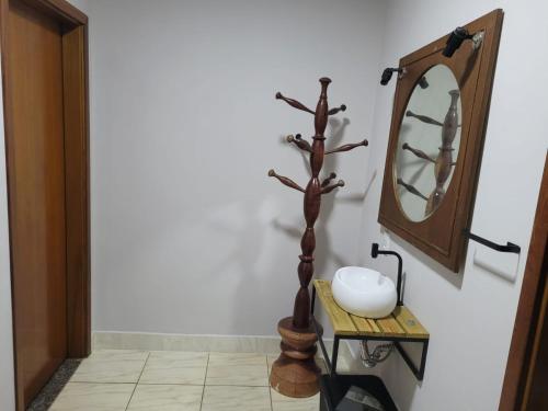 a bathroom with a mirror and a tree in front of a sink at POUSADA Chacara ENTRE NÓS in Holambra