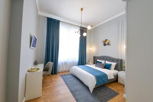 a bedroom with a bed and a desk and a window at Victoria's Old Town Deluxe Apartment in Timişoara