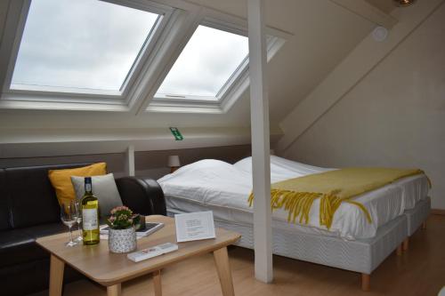 a bedroom with a bed and a couch and a table at Gastenverblijf De Arend in Nieuwpoort