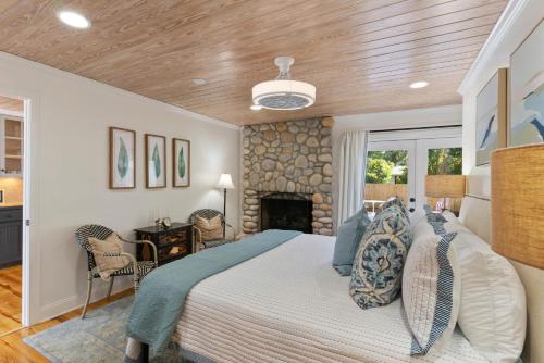 1 dormitorio con 1 cama y chimenea de piedra en Live Oak Retreat - 2104 Bruce Drive, en Saint Simons Island