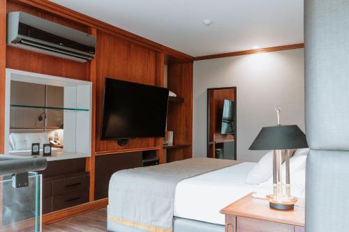 a hotel room with a bed and a flat screen tv at Hotel Park10 in Medellín