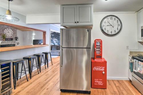 a kitchen with a refrigerator and a clock on the wall at New Hampshire Home with Private Beach, Dock and Rafts! in Barnstead