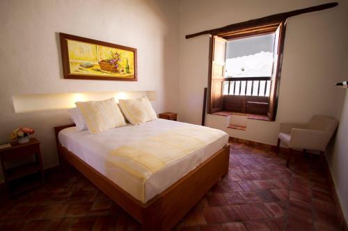 a bedroom with a large bed with a window at Misia Custodia Hotel Boutique in Barichara