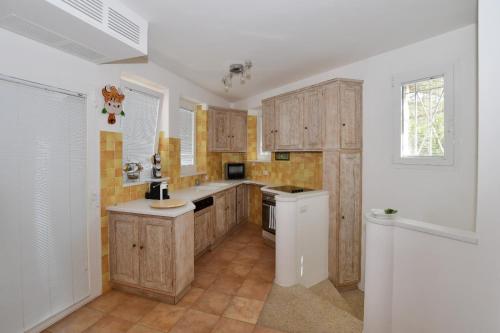 a kitchen with wooden cabinets and a sink and a window at [Villa indipendente piscina privata] e vista mare in Cala Bitta