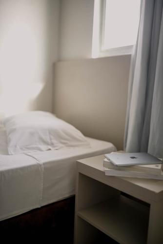 a bedroom with a bed and a table with a laptop at OK Inn Hotel Criciúma in Criciúma
