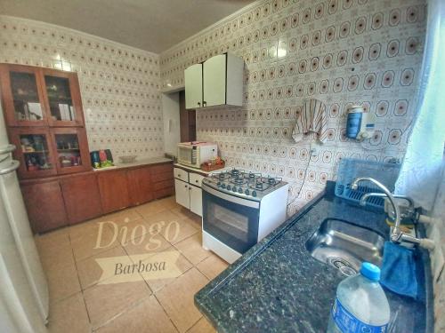 a kitchen with a sink and a stove top oven at Casa Praia Grande WIFI 2dorm 2ban 2carr churrasq 400mts da praia Tupi in Praia Grande