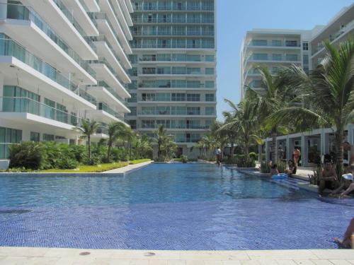 una piscina en un complejo con palmeras y edificios en Apartamento Morros Ultra 511, en Cartagena de Indias
