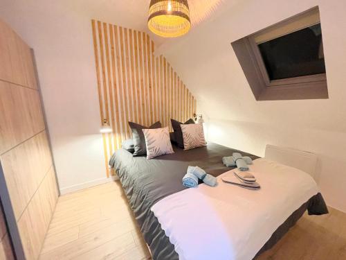 una camera da letto con un grande letto con asciugamani di La Suite ALOHA, Elegant & Cosy a Beauvais