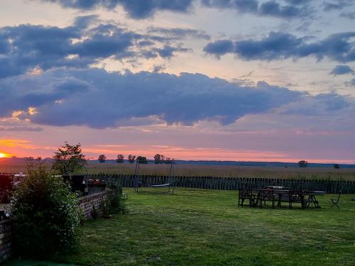 a sunset with a picnic table in a field at DOM GOŚCINNY PTASZARNIA - NATURA-Free PARKING in Świnoujście