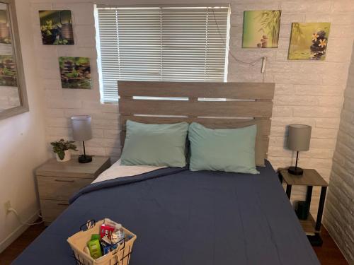 um quarto com uma cama com lençóis e almofadas azuis em Casa de Basswood em Tucson