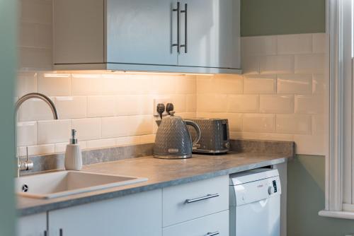 a kitchen with a sink and a counter top at Whitstable Hideaway by Bloom Stays in Whitstable