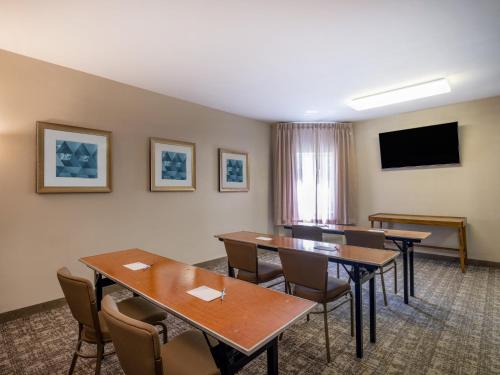 a conference room with tables and chairs and a flat screen tv at Staybridge Suites Milwaukee Airport South by IHG in Franklin