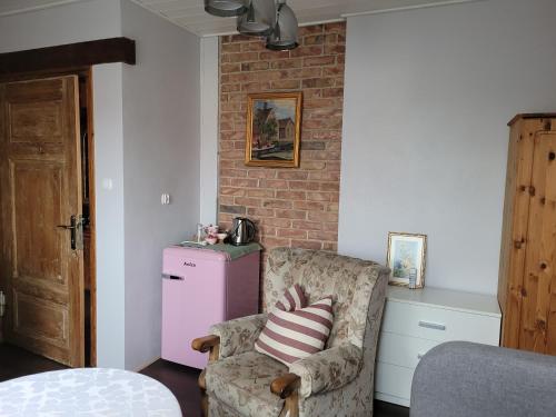 a living room with a chair and a brick wall at DOM GOŚCINNY PTASZARNIA - NATURA-Free PARKING in Świnoujście