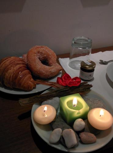 a table with two candles and a plate of food at Bed & Breakfast Al Ponte in Scanno