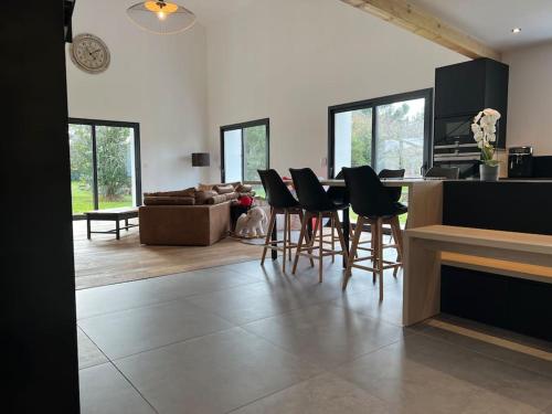 een keuken en een woonkamer met een tafel en stoelen bij Grange Luxe rénovée plein centre in Arsac