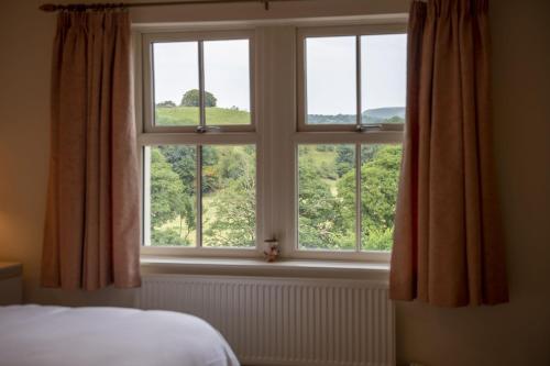 ventana del dormitorio con vistas a un campo verde en River View en Ingleton 