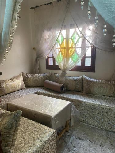 - un salon avec un canapé et un vitrail dans l'établissement Anacaccia, à Marrakech