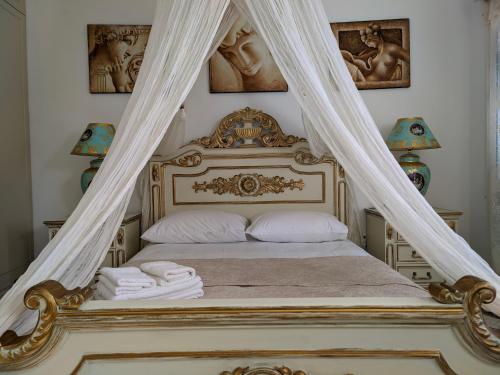 1 dormitorio con cama con dosel y sábanas blancas en Lakena Sunset View Villa, en Menetaí