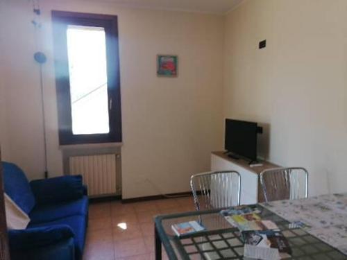 a living room with a table and a blue chair at Casa Laghetto in Castellaro