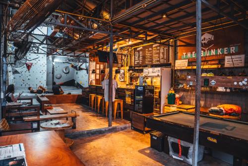 un restaurante con mesas y una mesa de billar en Warehouse Hostel Koh Tao, en Ko Tao