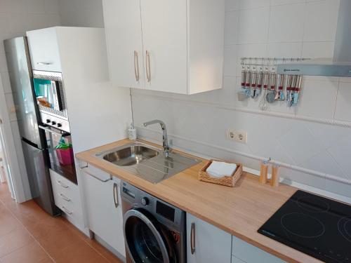 a kitchen with a sink and a washing machine at Albatros Golf Costa Esuri Ayamonte Huelva in Huelva