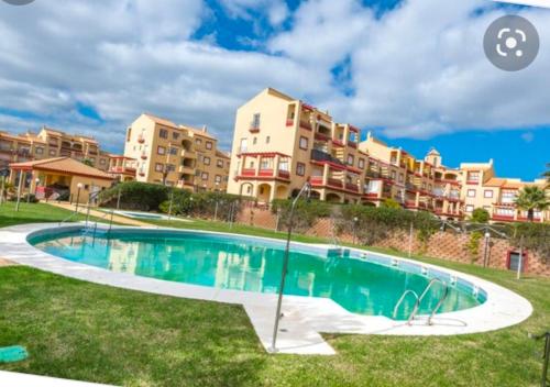 una piscina di fronte a un complesso di appartamenti di Albatros Golf Costa Esuri Ayamonte Huelva a Huelva