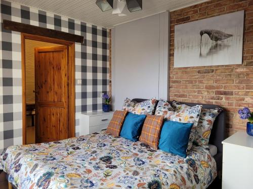 a bedroom with a bed with blue pillows at DOM GOŚCINNY PTASZARNIA - NATURA-Free PARKING in Świnoujście
