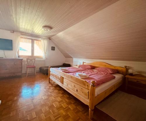 1 dormitorio con cama de madera en una habitación en Apartmaji Katrnjek, en Bohinj