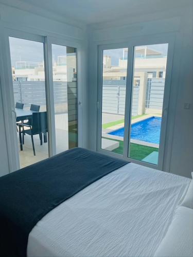 1 dormitorio con cama y vistas a la piscina en vistabella golf maui, en Alicante
