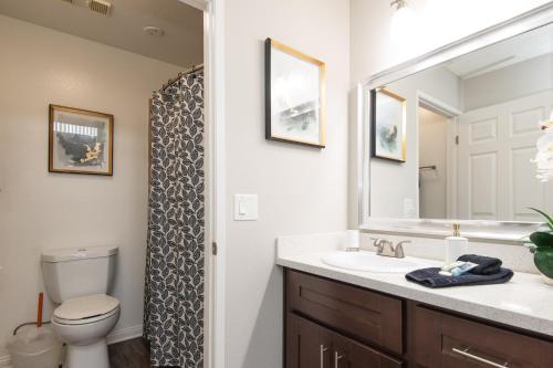 ein Badezimmer mit einem Waschbecken, einem WC und einem Spiegel in der Unterkunft Executive Studio Jr One Bedroom with Balcony and Pool in Los Angeles