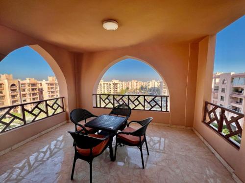 balcón con mesa, sillas y 2 ventanas en Luxurious 3 BR Rustic Apartment Overlooking Huge Garden - For Families and Couples en El Cairo