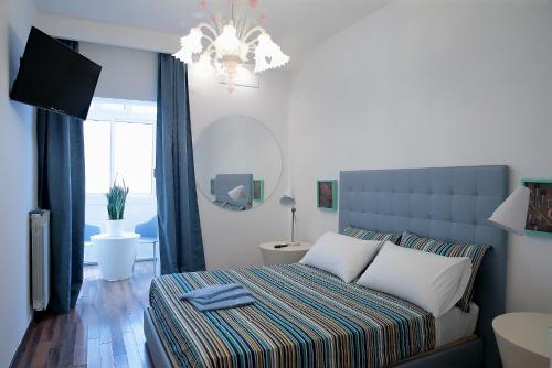 um quarto com uma cama e um lustre em SAVOIA & CAVOUR _ Premium Signature _ em Bari