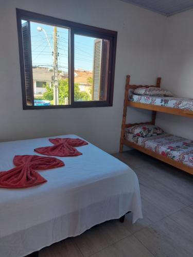 Un dormitorio con una cama con toallas rojas. en H&C Pousada, en São Gabriel