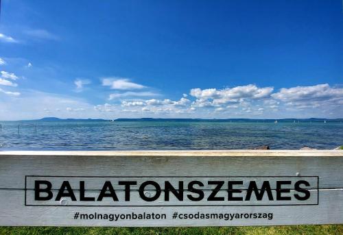 a sign that reads balmoralneses on a wall near the water at Kikötő Sétány Apartman III. in Balatonszemes