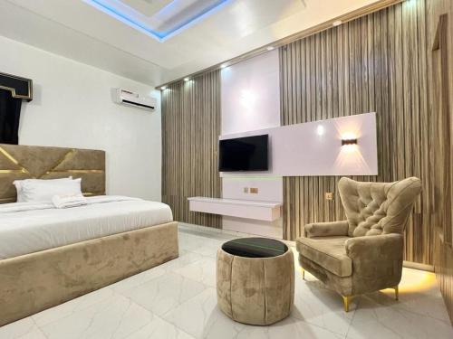 a bedroom with a bed and a couch and a chair at Clique Court Hotel & Suite in Opete